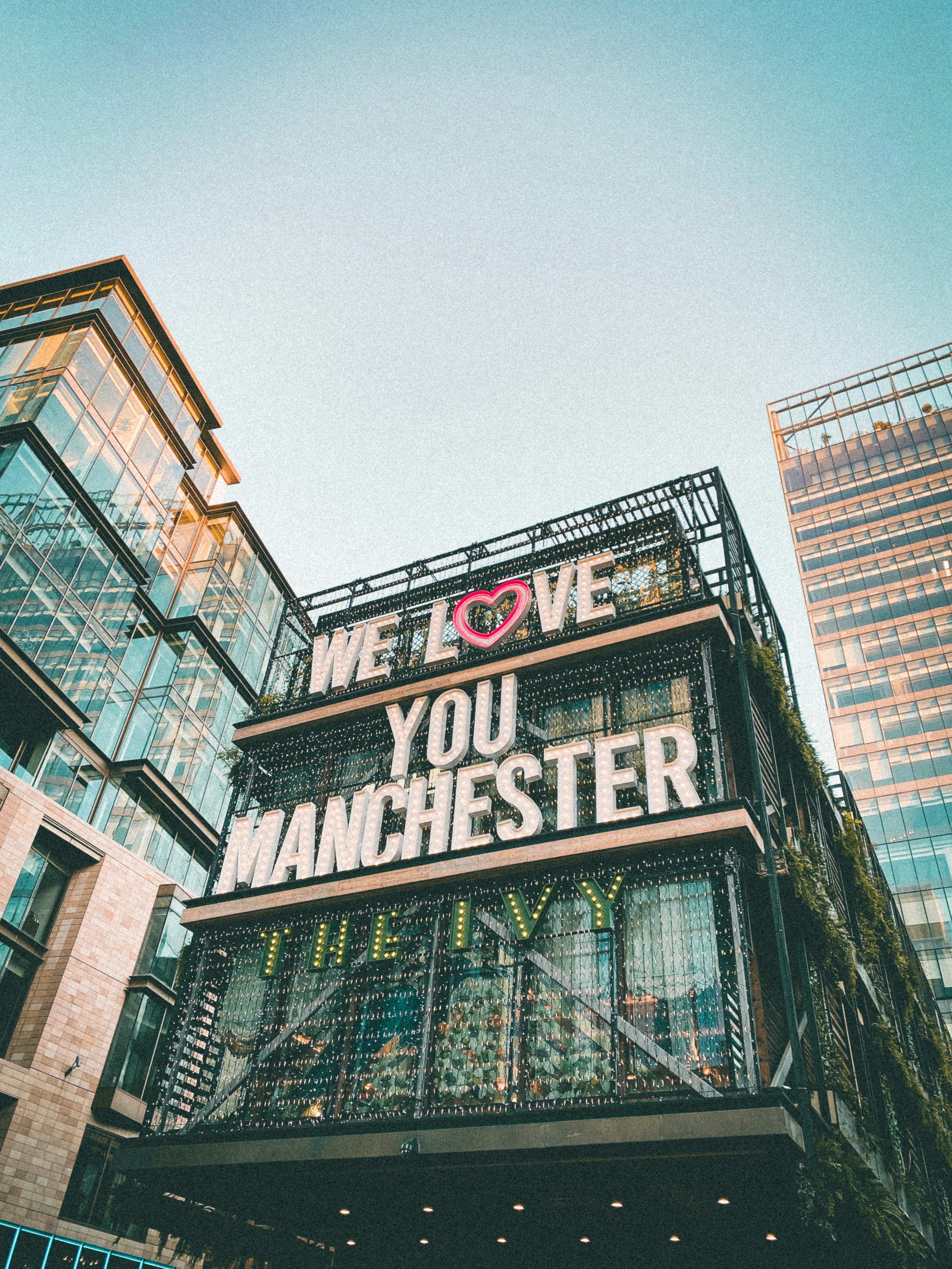 A modern building with 'We Love You Manchester' written on the side. 