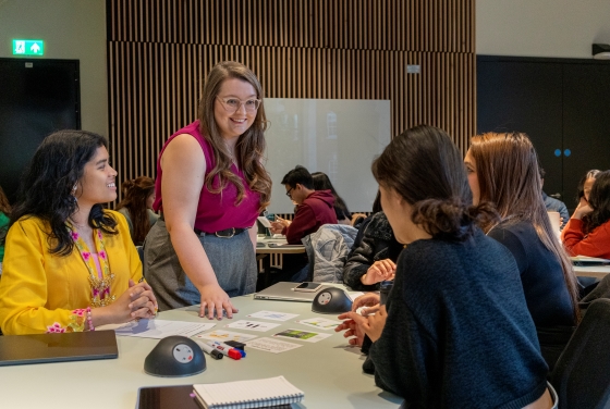 An LSE100 teacher with students in a classroom
