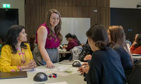 An LSE100 teacher with students in a classroom