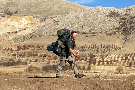 Timothy Chattell walks across a desert landscape