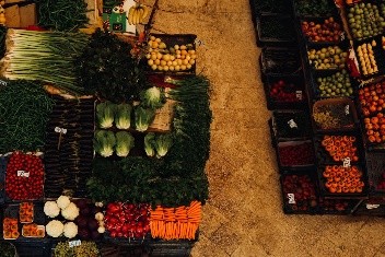 Overhead view of a fresh produce market stall filled with neatly arranged colourful vegetables and fruits