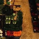 Overhead view of a fresh produce market stall filled with neatly arranged colourful vegetables and fruits