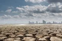 Landscape of parched, cracked ground and distant city skyline, showing drought and environmental degradation