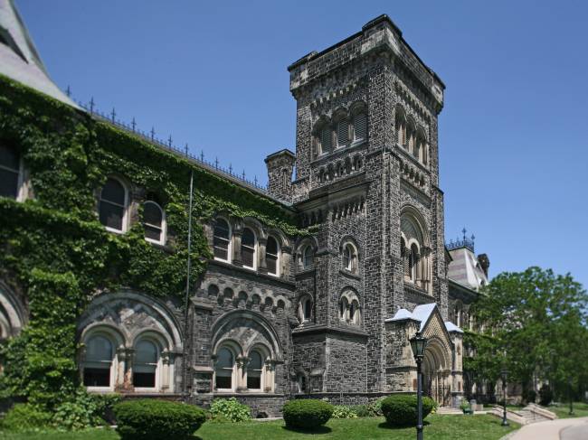 University of Toronto old building in castle style with ivy on walls on a summer day