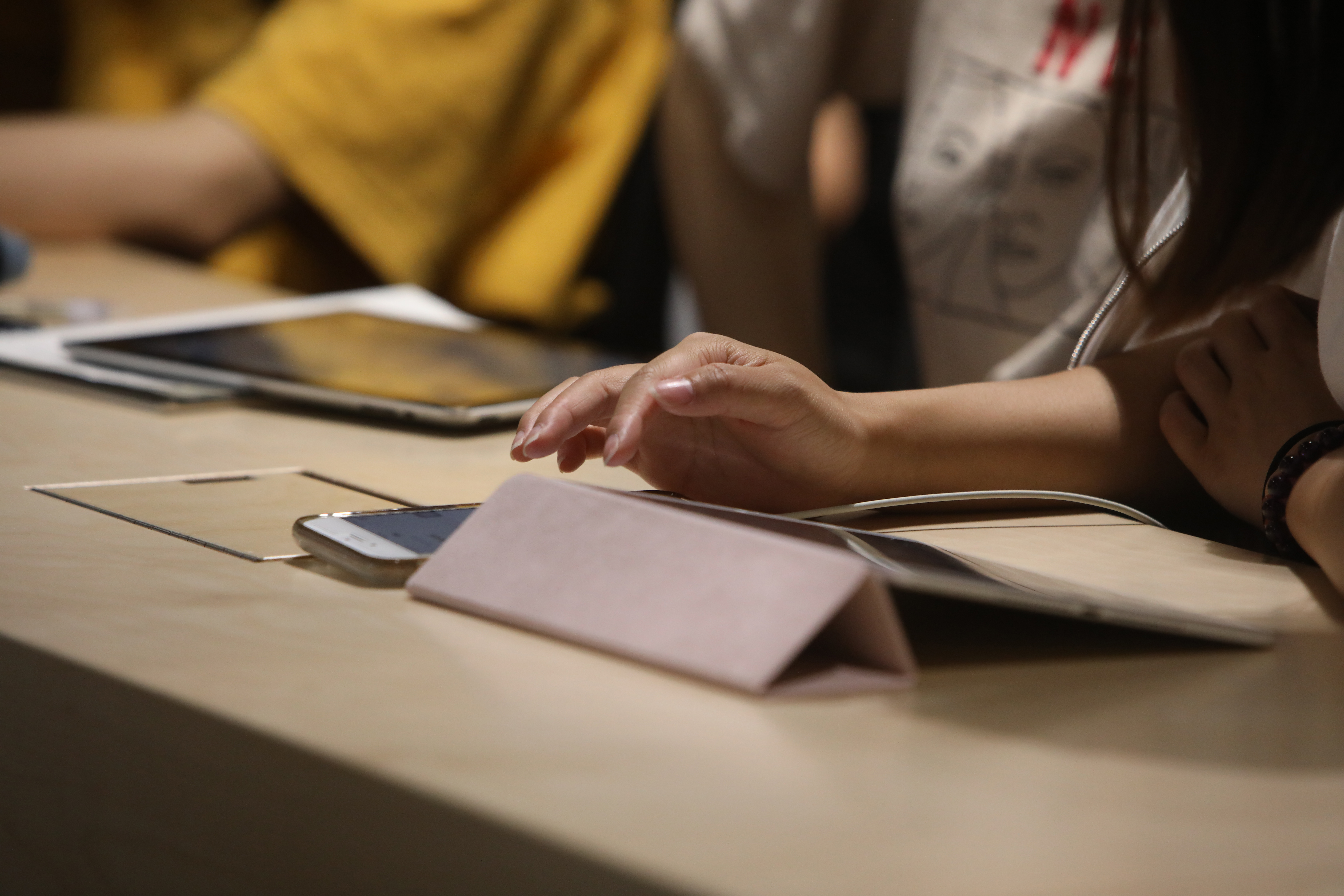 a close up of a desk with ipads and a phone in use