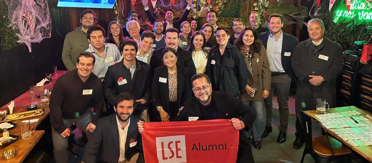 Alumni pose for a group photo during a Halloween-themed Welcome to the City event in Chile.