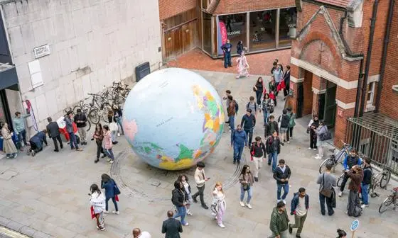 Students walk past the globe on LSE campus during Welcome