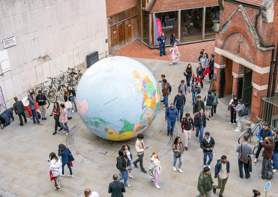 Students walk past the globe on LSE campus during Welcome