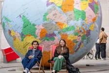 Two people sitting in front of LSE's globe in deck chairs