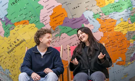 Two students sitting in front of LSE's globe