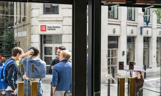 A group of students stand in front of the entrance to the DSI