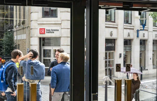 A group of students stand in front of the entrance to the DSI