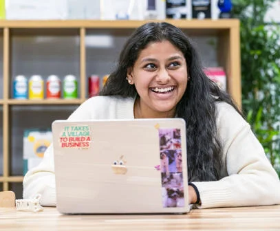 Student working on her laptop and smiling