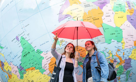two girls stranding in front of globe