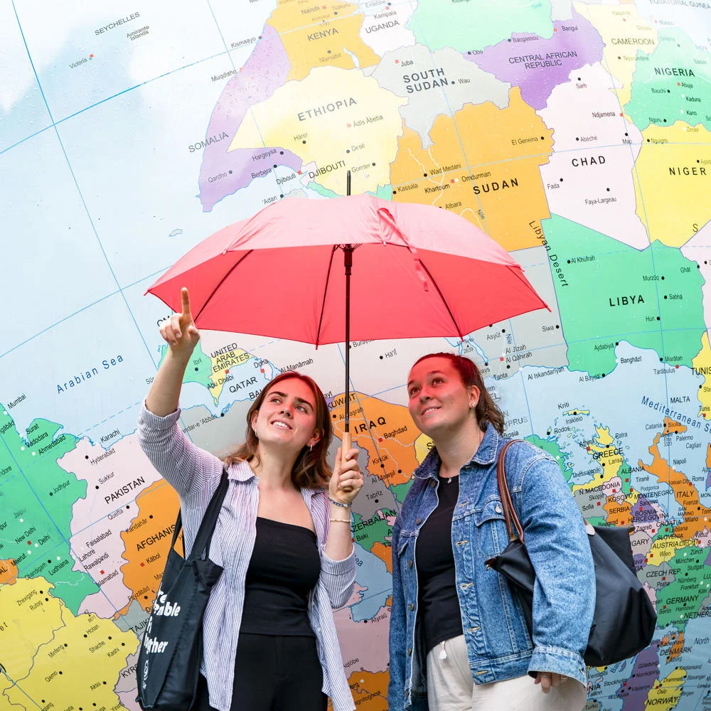 two girls stranding in front of globe