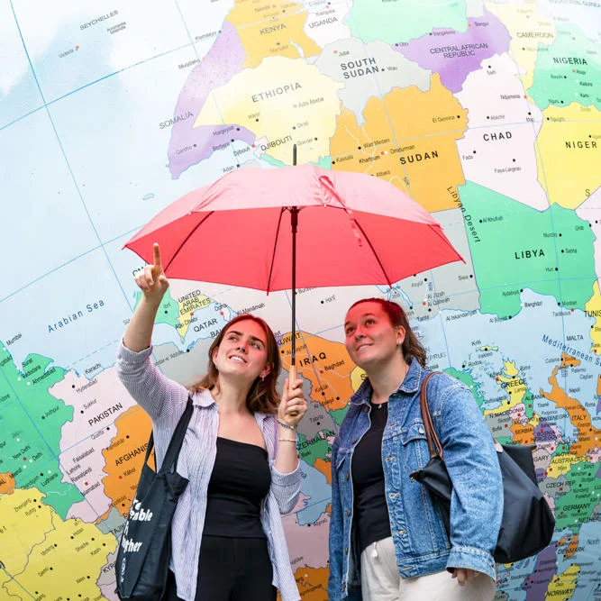 two girls stranding in front of globe