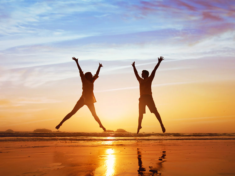 Two people jumping on a beach
