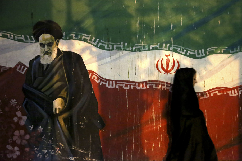 Woman walks past a mural of Ayatollah Ruhollah Khomeini in Tehran. Source: Michael Llyod, Flickr, CC by 2.0