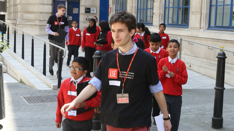 An LSE student leads a group of children