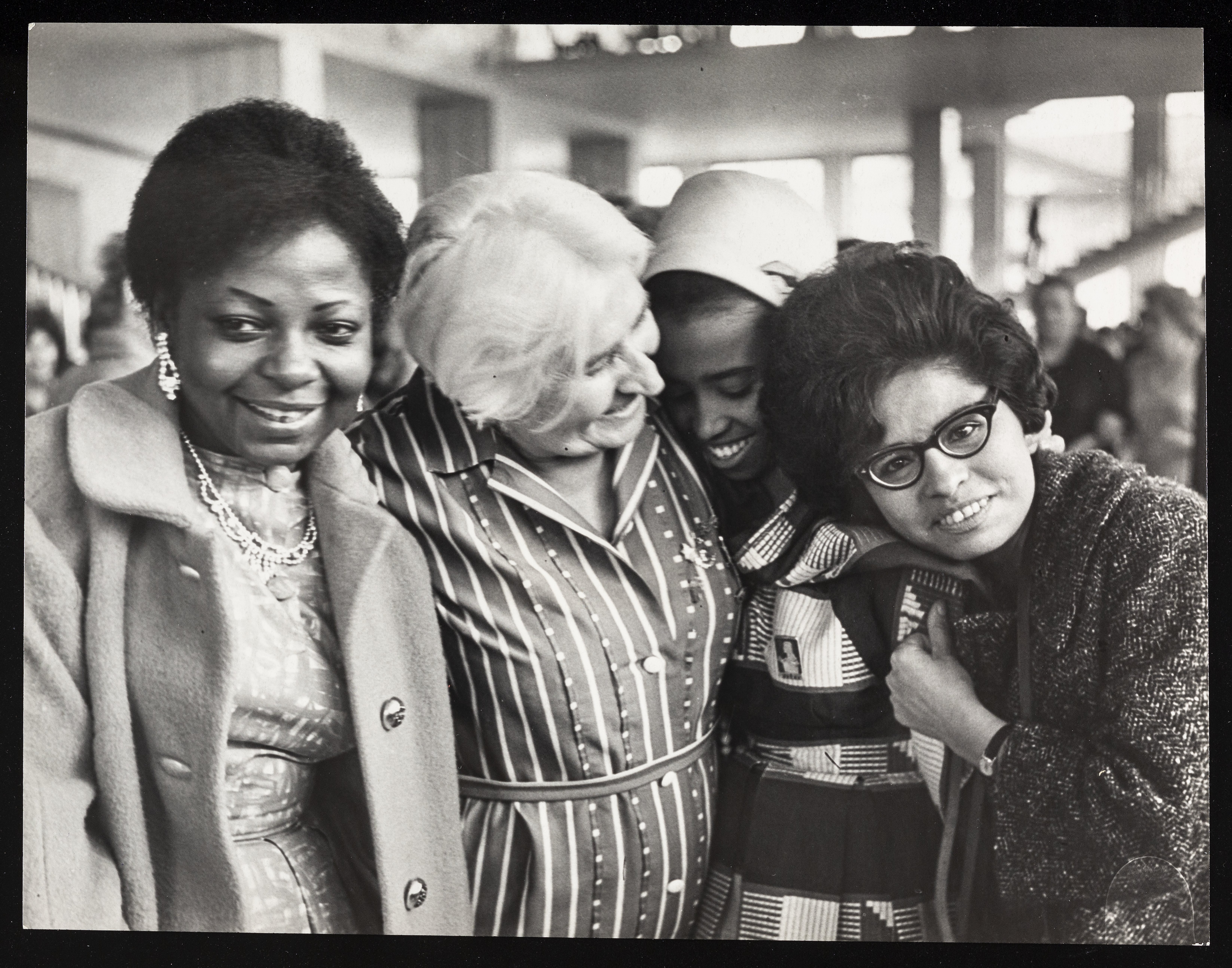 A black and white photograph showing four women smiling from the collection at the Women's Library at LSE. 