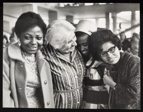 A black and white photograph showing four women smiling from the collection at the Women's Library at LSE.