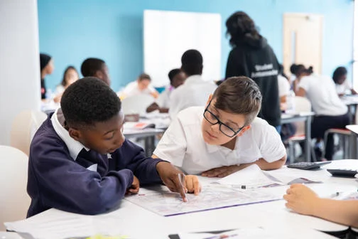 School pupils looking at paper resources while visiting LSE