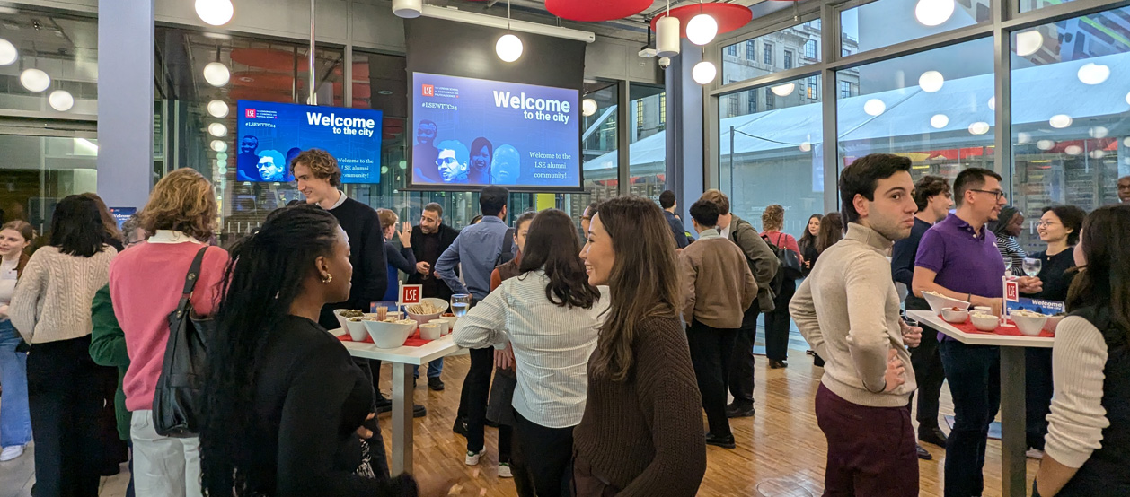Alumni gather around tables to network and chat at LSE's Welcome to the City.