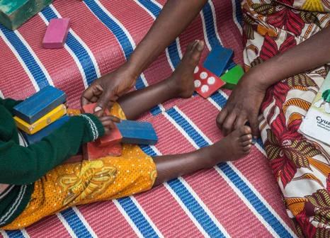 Cretaker from the Imbuto Foundation with a child in Rwanda.