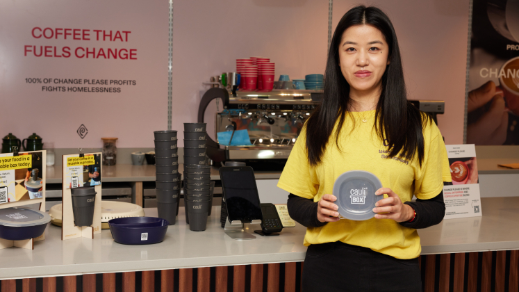 Mingqiao stands in a coffee shop holding a CauliBox
