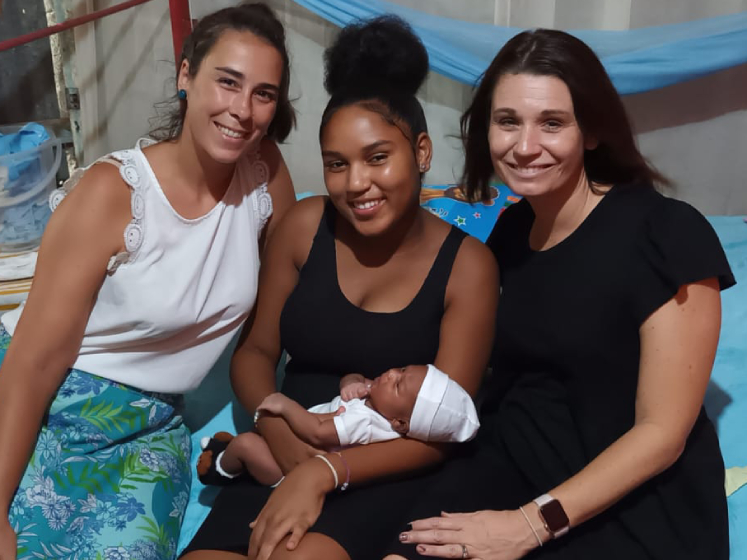 Ana Martin and a friend sit beside a  former shelter service user and her baby