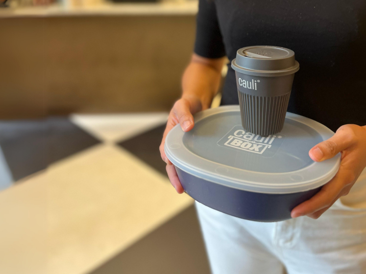 A person holds a CauliBox and a CauliCup