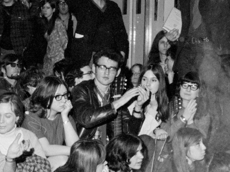 Black and white image of Tony and Phoebe surrounded by other students during a sit-in protest at LSE