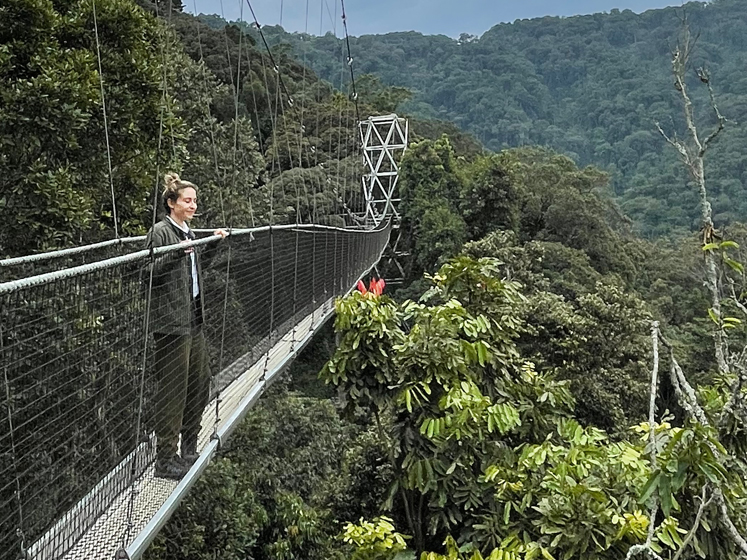 Ottavia Pesce stands on a slim suspension bridge above forested hills