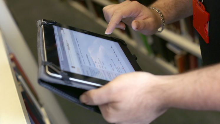 A person taps a tablet screen