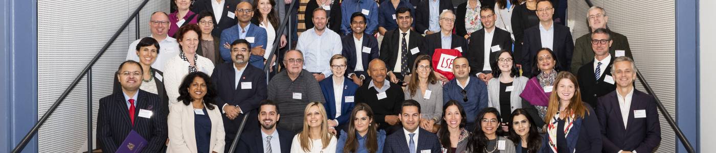 LSE alumni volunteers sit on the stairs at the Centre Building