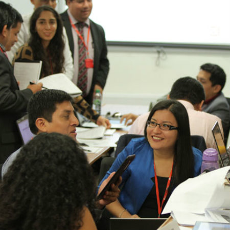 A group of people studying in a busy room.