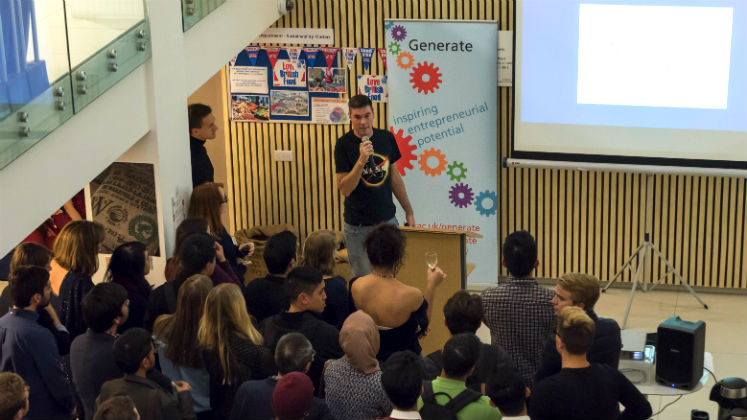 A group of people watching a speaker on stage | LSE Generate