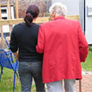 two_women_walking_red_jacket_behind_130x130