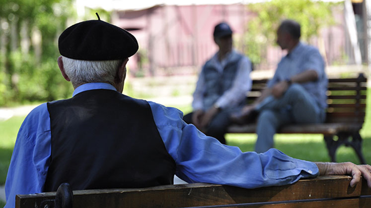 man_alone_on_bench_looking_at_others_747x420