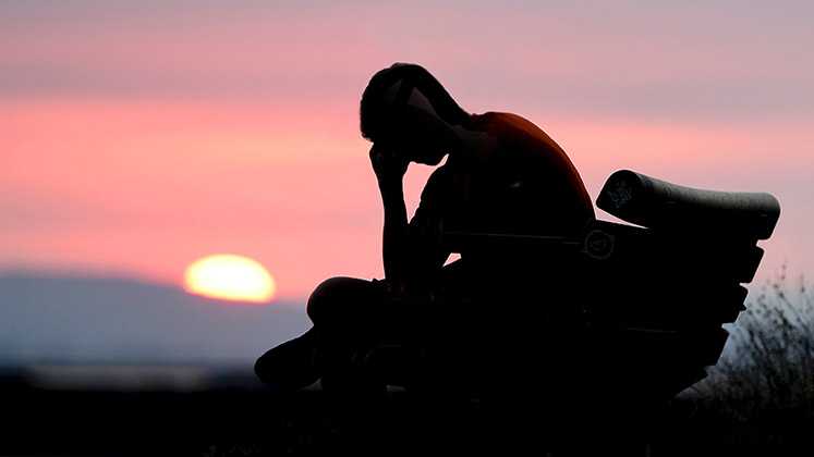 sunset_man_head_in_hands_bench_747x420