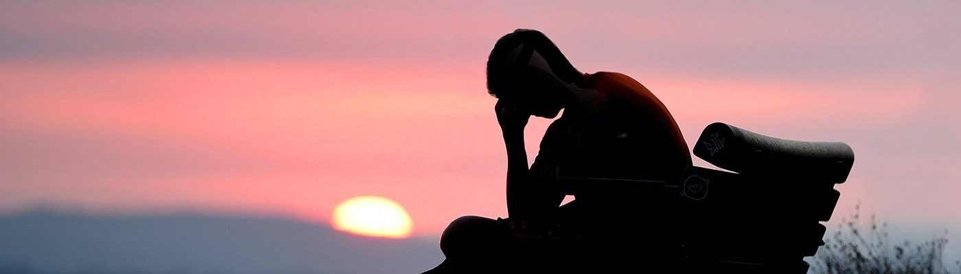 sunset_man_head_in_hands_bench_1400x400