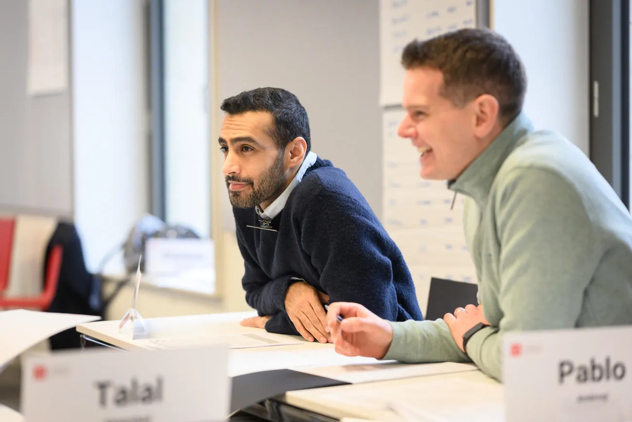 Two male Executives listening and smiling in class
