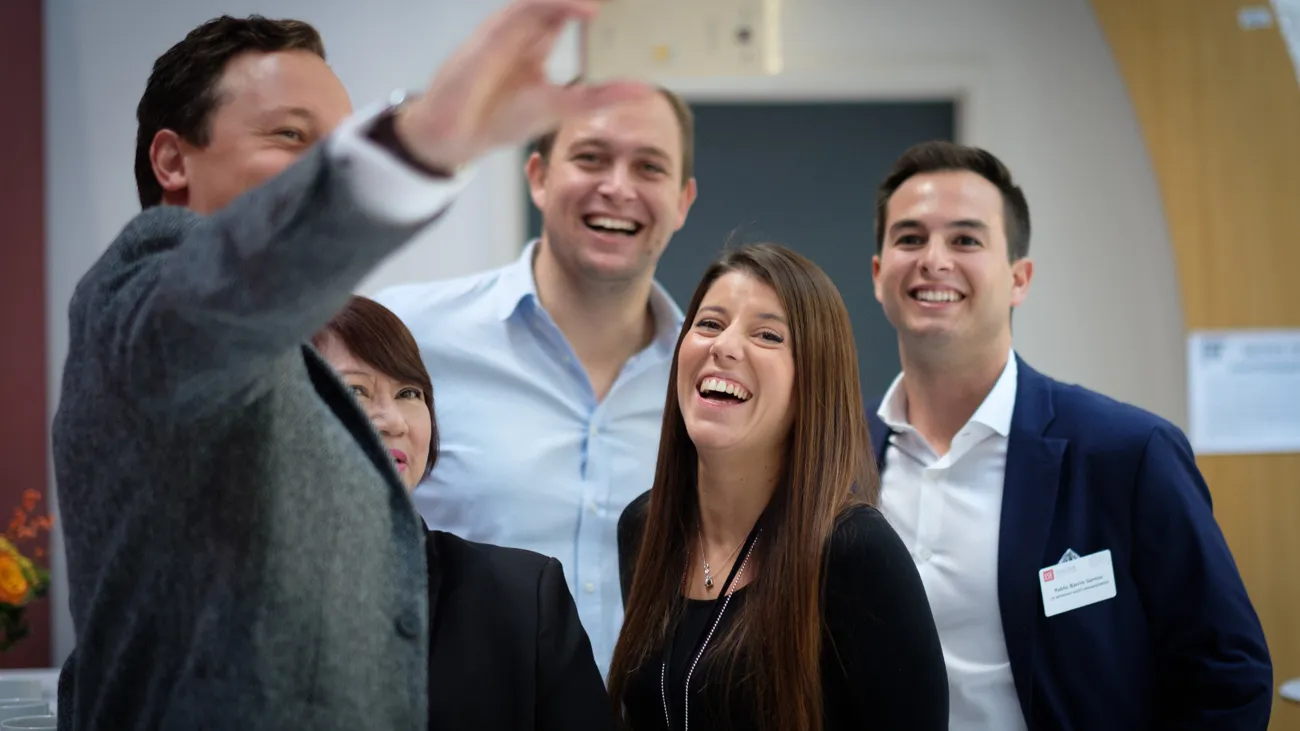 Four executives smiling and taking a selfie