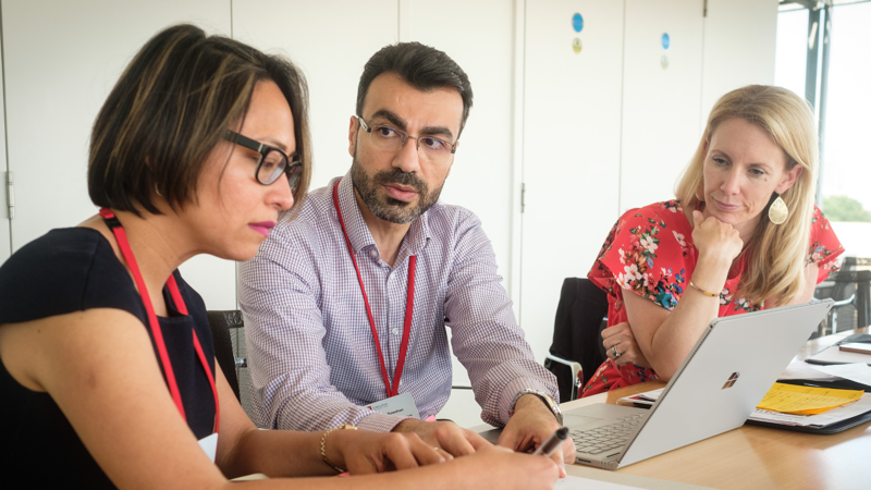 A man and two women working together on a laptop Leading Risk in Organisations