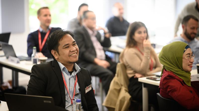 A man and other class participants smiling in class Brand Strategy