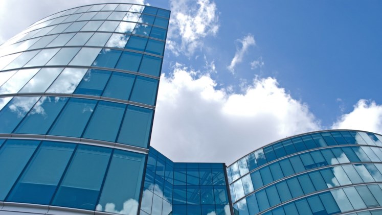 Glass city building against blue skies