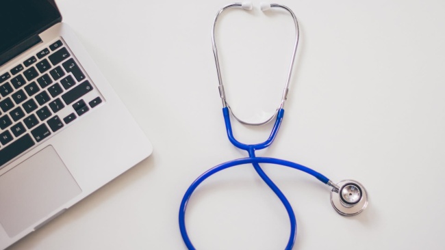 Close up photo of a laptop and a stethoscope