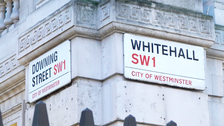 Photo of the street signs at the corner of Downing Street and Whitehall.