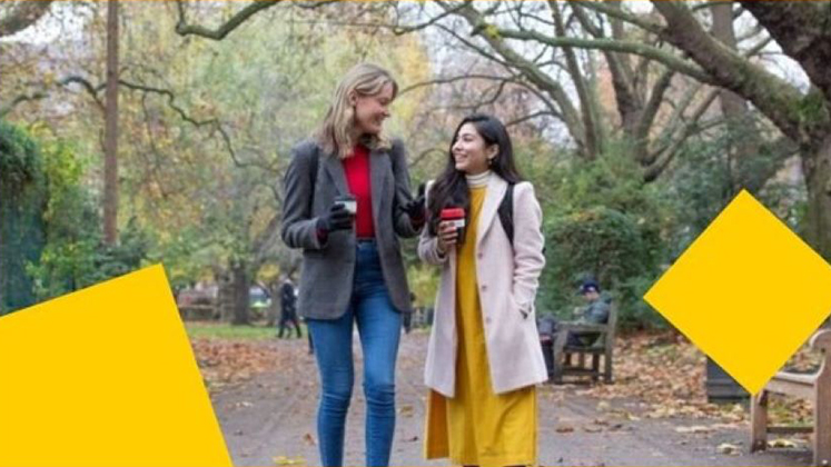 Two students walking in the park having a chat.