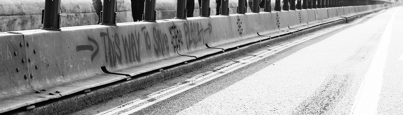 Graffiti on Waterloo Bridge during an environmental protest saying, "this way to save the planet"